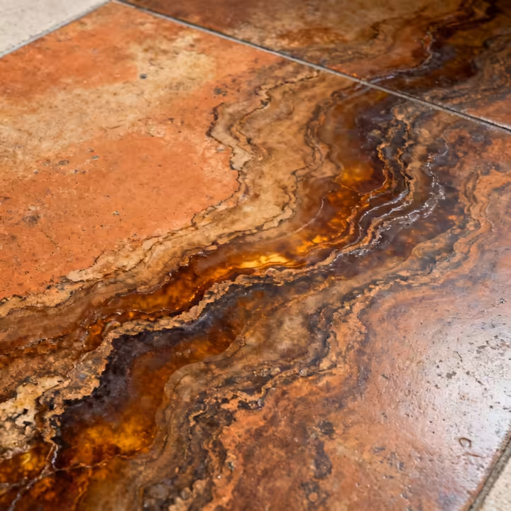 A close-up of an acid-stained concrete floor showing its unique, mottled, and stone-like appearance.