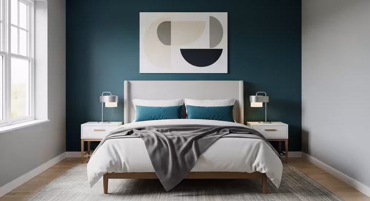 A modern bedroom with a bold, dark teal accent wall behind the bed, which serves as a dramatic focal point for the room.